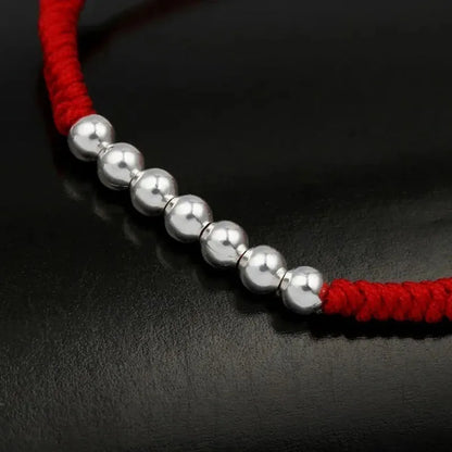 Pulsera Hilo Rojo con nudos y esferas plateadas