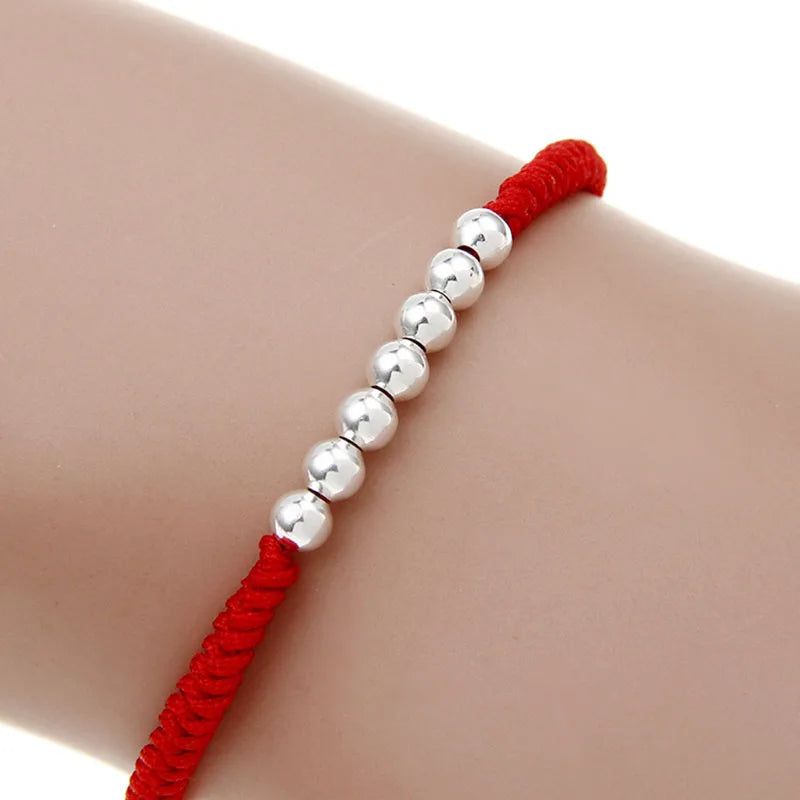 Pulsera Hilo Rojo con nudos y esferas plateadas